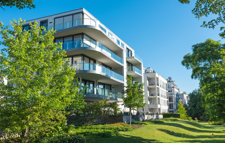 Immeuble neuf avec des balcons et une pelouse verte